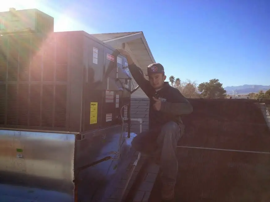 HVAC technician performing Boiler Repair on a rooftop unit in Indiana